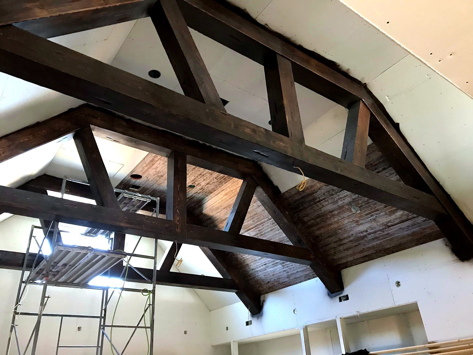Vaulted tongue-and-groove wood ceiling with an exposed wood king-post truss and skylights