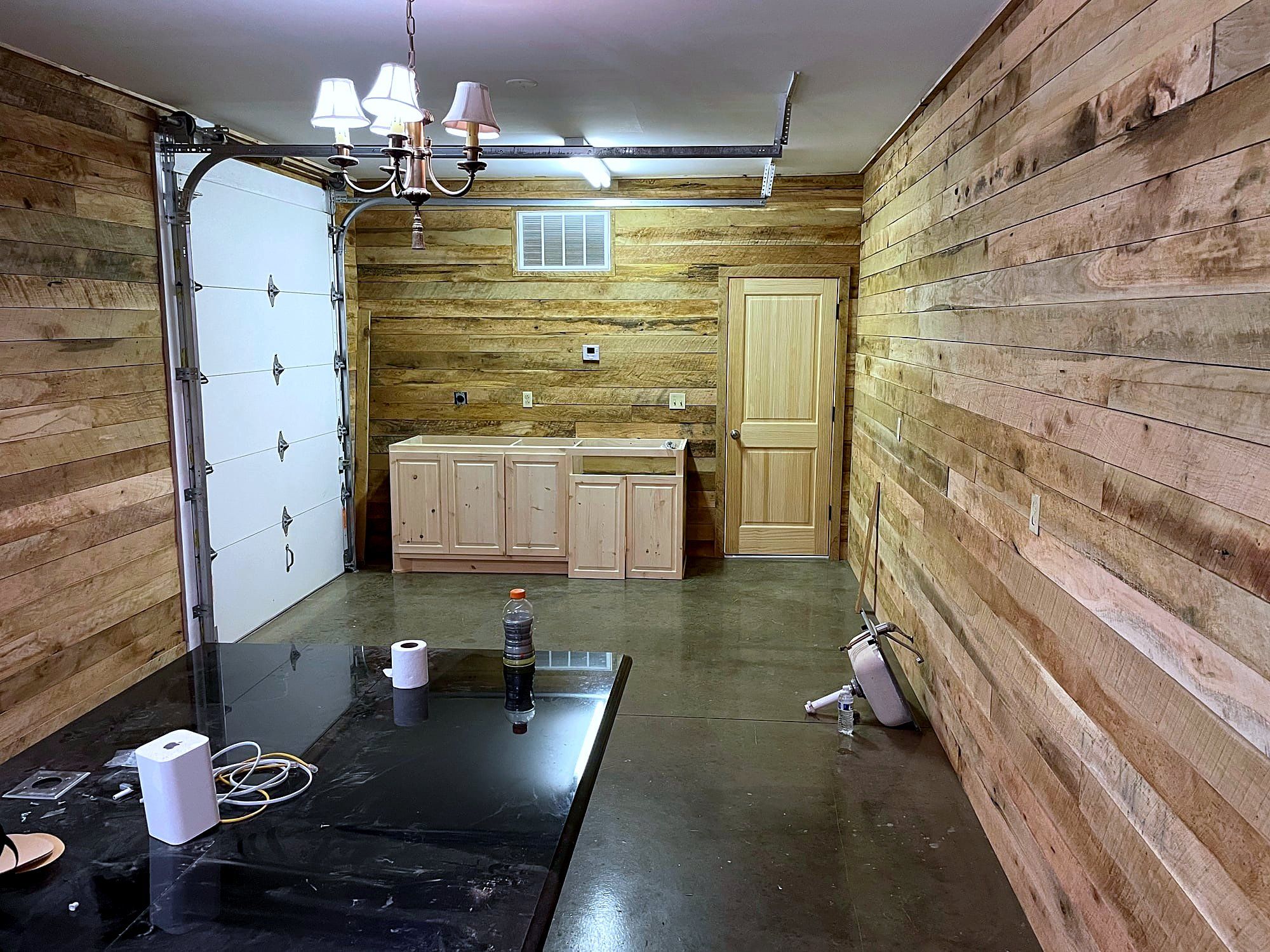 Garage remodel with reclaimed wood plank walls on both sides and a hanging chandelier