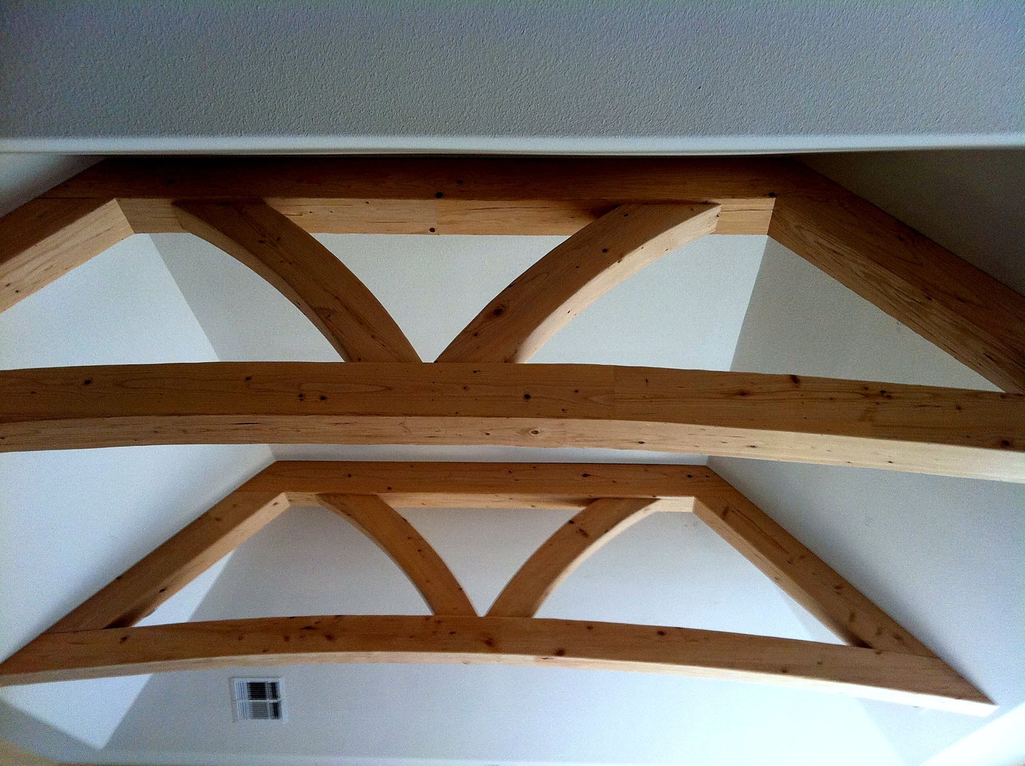 Vaulted ceiling with a repeating pattern of exposed wood king-post trusses