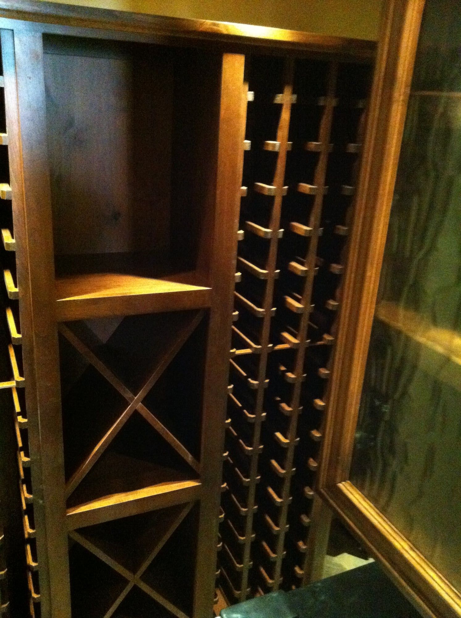 Close view of a dark wood wine rack cabinet with diagonal bottle storage